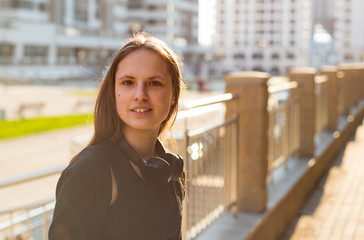 Outdoor portrait of young teenager brunette girl with long hair. girl on city in black dress