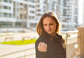 Outdoor portrait of young teenager brunette girl with long hair. girl on city in black dress