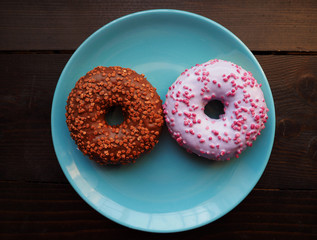 Donuts on the blue plate on the wooden table
