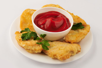 Fried chicken nuggets and parsley on an isolated gray background