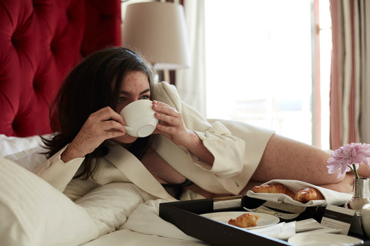 Teenage girl having breakfast in bed