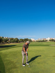 athletic and attractive man playing golf on a sunny day