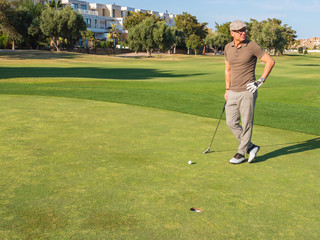 athletic and attractive man playing golf on a sunny day