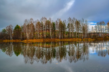 Autumn landscape sunny warm day in the forest by the river