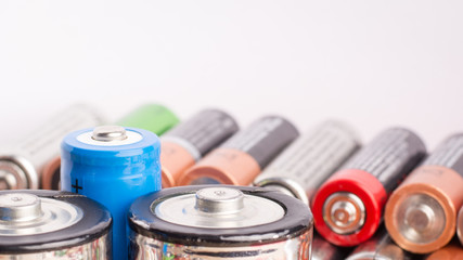 Stack of different batteries against a white background