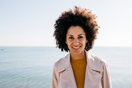 Portrait of smiling woman with the sea in background