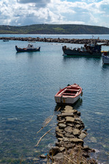 Seascape with pier, quiet sea harbor with clear transparent water and traditional greek fisher boats