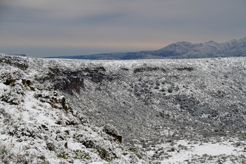 The desert of Arizona covered in snow with distant mountains.
