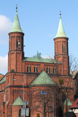 Fototapeta na wymiar Catholic temple, Catholic church, Catholic church. Cross in front of the church, red brick church