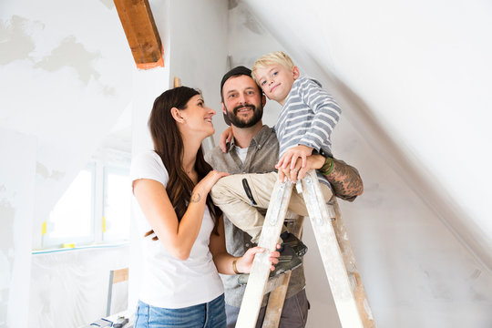 Portrait of happy family working on loft conversion