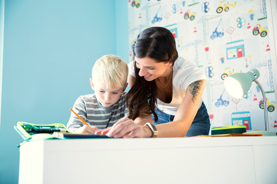 Mother helping son doing homework at desk