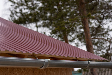 fragment of the metal roof of the house. Red roof