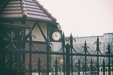 Clock germany cuckoo forest vintage triberg, clock on the old house, tinted photo, iron fence