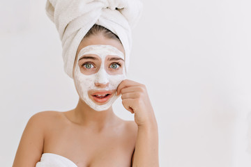 Portrait of beautiful young woman  with towels after take bath make cosmetic mask and worries about her skin. Rejuvenation,cosmetology, spa and care face. Clean and perfect skin.White background