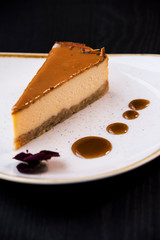 Caramel cheesecake on trendy plate with caramel sauce. gourmet conception.