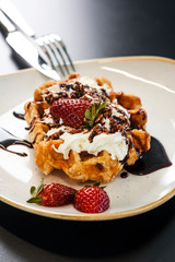 Sweet pastries with fresh strawberries, cream and chocolate sauce. Gourmet conception, cuisine art.