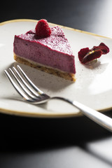 Raspberry cake with cashew on a trendy plate. Gourmet conception.