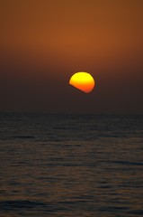 Sunset with large yellow sun under the sea surface