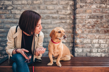 Woman sitting on the bench and talking with her dog