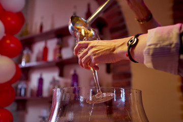 Fototapeta na wymiar Bartender pours fruit punch in wine glass.