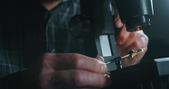 Slow motion close up of experienced goldsmith controlling a quality of diamond stone, selected for making jewels in workshop. Shot in 8K. Concept of jewelry,luxury,goldsmith, diamonds, brilliance.