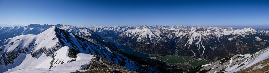 Bergpanorama vom Unnütz über den Aachensee bis in das Karwendel im Frühjahr mit Schnee auf den Bergen und grünem Tal