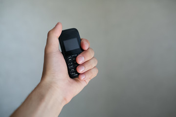 Close-up of man hand holding old black mobile phone