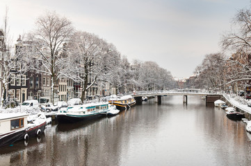 Fototapeta na wymiar Snow covered Amsterdam canal in cold winter. Amsterdam is the capital of the Netherlands.