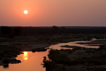 Sunset over a red coloured river in Kruger national park, South-Africa.