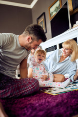 Smiling family having fun with cute child