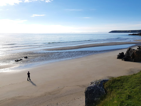 Man walking by shimmering water