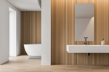 Obraz premium Stylish white and wooden bathroom, tub and sink