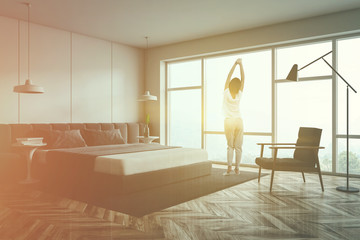 Woman in pajamas in panoramic bedroom corner