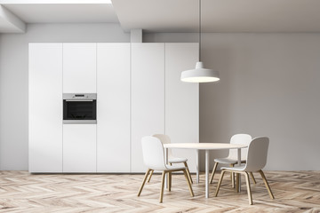 White kitchen interior, cupboard and table