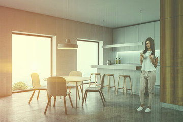 Woman in kitchen corner with bar and table