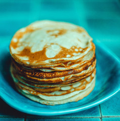 Pancakes lying on a blue plate. A traditional dish.