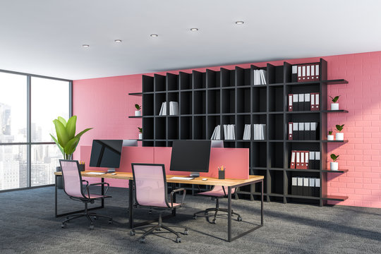 Side view of pink office workplace with bookcase