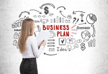 Woman with copybook looking at business plan