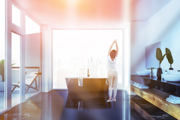 Woman in white bathroom with balcony