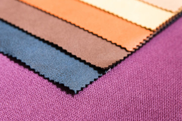 Colorful and bright fabric samples of furniture and clothing upholstery. Close-up of a palette of textile abstract stripes of different colors