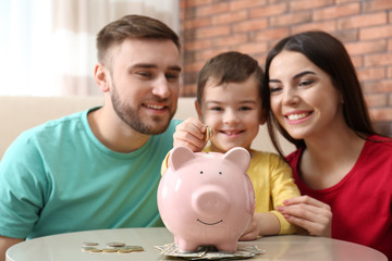 Obraz na płótnie Canvas Happy family with piggy bank and money at home
