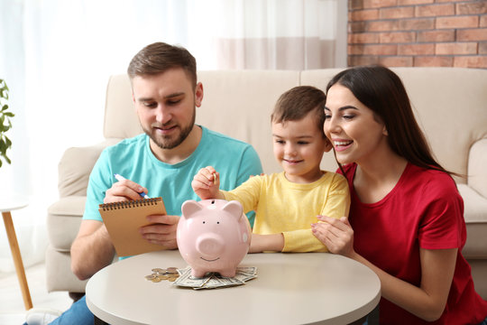 Happy family with piggy bank and money at home