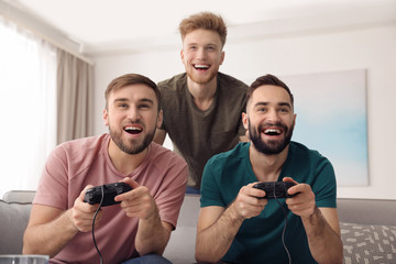 Emotional friends playing video games at home © New Africa