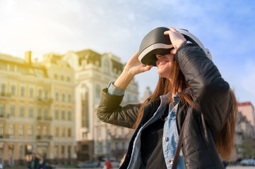 Beautiful young brunette wearing virtual reality headset in an urban context