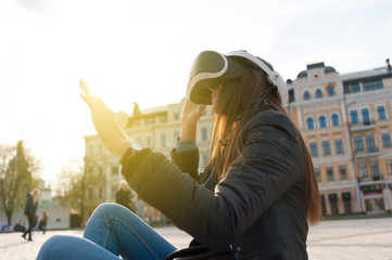 Beautiful young brunette wearing virtual reality headset in an urban context