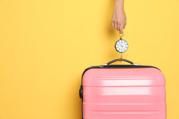 Woman weighing suitcase against color background, closeup. Space for text