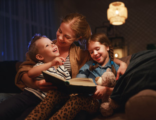 evening family reading. mother reads children . book before going to bed .