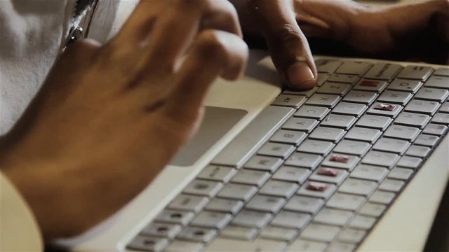 Hands of a Blind or Visually Impaired School Boy learning to Use a Computer with Highlighted Keys to Aid Visually Impaired People. Close Up. 