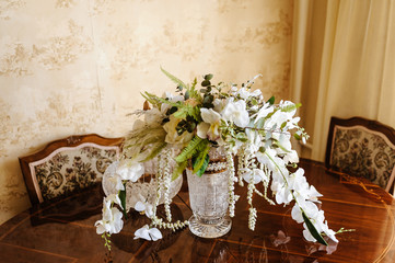 bridal bouquet in a chic crystal vase on a carved lacquered wooden table close-up