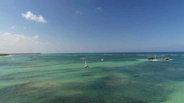 Tropical vacation in Punta Cana, Dominican Republic. Aerial view over beach resort. Parasailing. Yachting. Catamaran and speed boats in the sea.ort Punta Cana, Dominican Republic. Summer vacation. 